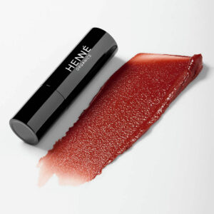 Henne Intrigue Tinted Lip Balm, a buildable brick red hue.