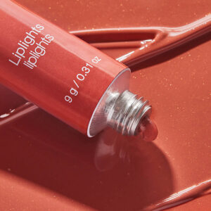 RMS Liplights Cream Lip Gloss Bisou is a muted coral hue.